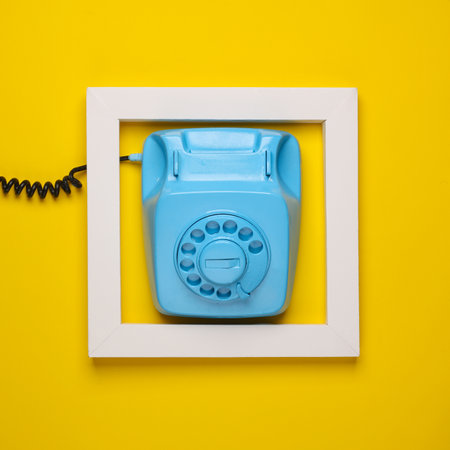 Retro rotary telephone in white frame on yellow background. Creative layout. Minimalismの写真素材