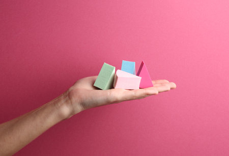 Makeup sponge blenders in female hand on pink backgroundの写真素材