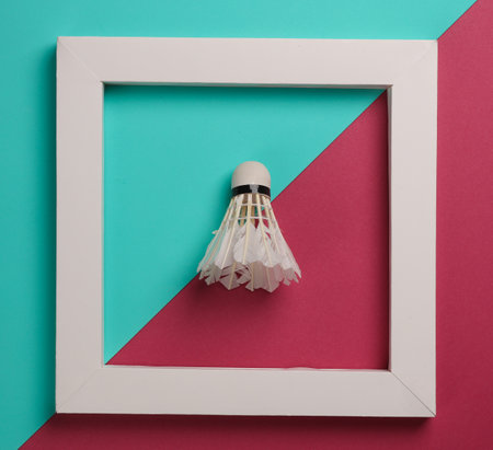 Shuttlecock in white frame on pink blue background. Creative layout. Minimalism