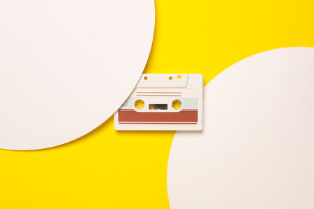 Retro 80s audio cassette on yellow background with white circles. Music concept, Creative layout....