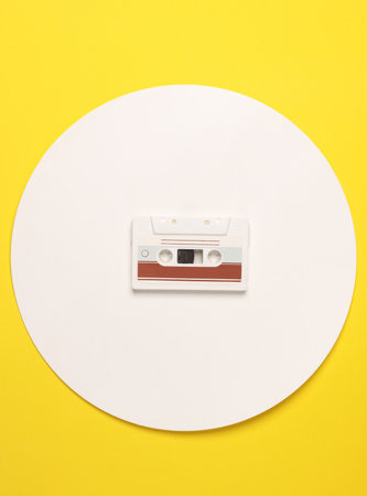 Retro 80s audio cassette on yellow background with white circle. Music concept, Creative layout. Top...