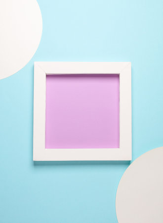 white square frame on blue background with circles. Aesthetic minimal still life. Conceptual photo....