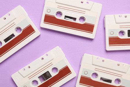 Retro 80s audio cassettes on purple background. Music concept, vintage technology. Top viewの写真素材