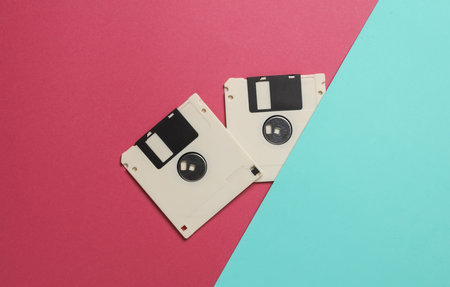 White floppy disks on a blue pink background. Retro technology. Top view
