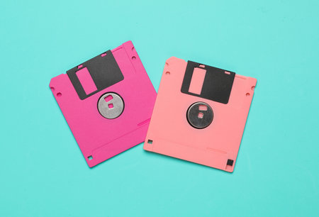 Pink floppy disks on blue background. Computer technology 80s. Top view.の写真素材
