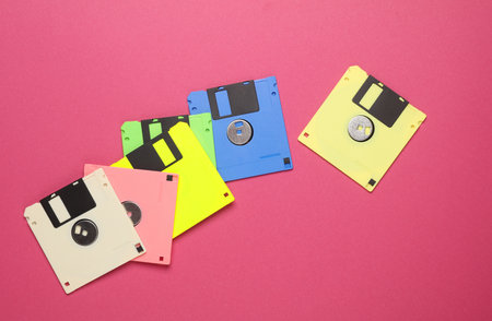 Many colored floppy disks on pink background. Computer technology 80s. Top view.の写真素材