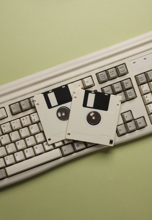 Retro keyboard and floppy disks on a green background. Top viewの写真素材