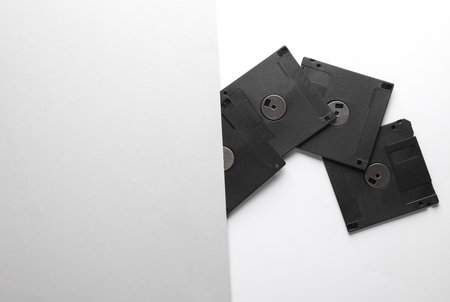 Set of black floppy disks on white gray background. Top view