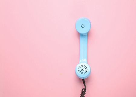 Retro blue telephone receiver on a pink background. Pastel color trend. Minimalismの写真素材