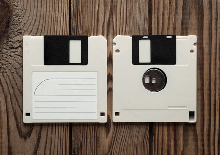 Retro 80s floppy disks on wooden background. Vintage technology. Top view.