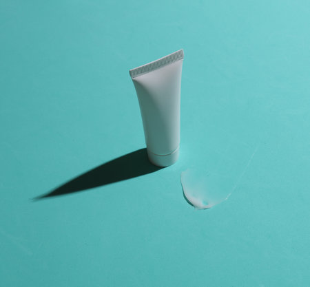Mockup of white tube with smear of cream on blue backgroundの写真素材