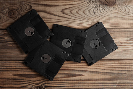 Retro 80s floppy disks on wooden background. vintage technology. Top view.