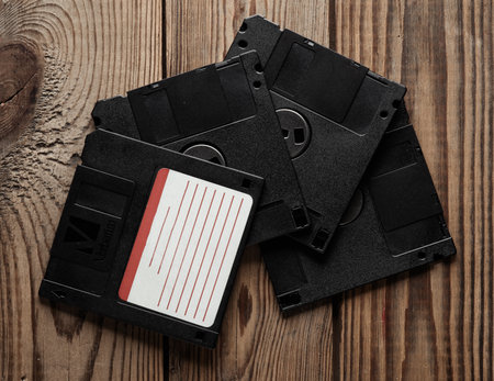 Retro 80s floppy disks on wooden background. vintage technology. Top view.
