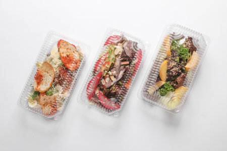 Different Salads in a plastic box on a white background. Tekaway food.