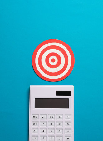 Calculator with a target on a blue background. Business concept