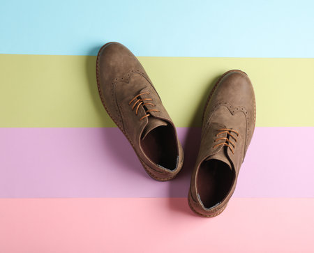 Stylish brogue shoes on colored pastel background. Men's footwear. Top viewの写真素材