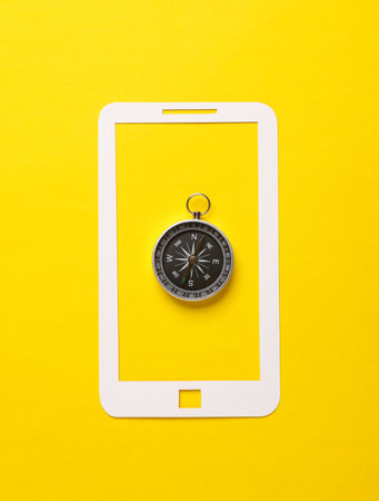 Paper-cut smartphone icon with compass on a yellow background. Navigation