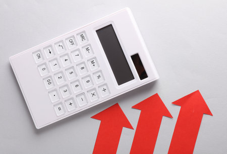 Calculator with red arrows on a gray background. Business conceptの写真素材
