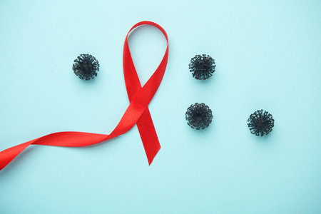 Red AIDS awareness ribbon and virus strain molecule on blue backgroundの写真素材