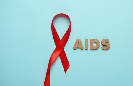 Red AIDS Awareness Ribbon on Blue Background