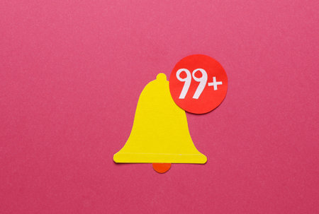 Paper cut notification bell icon on pink backgroundの写真素材