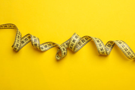 Measuring tape on a yellow background