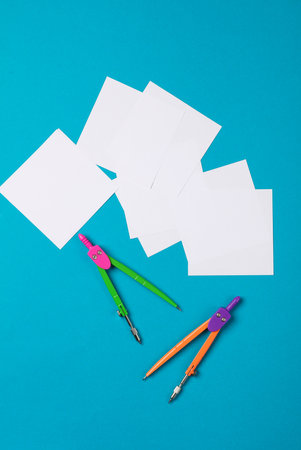 White square memo papers with compasses on a blue background