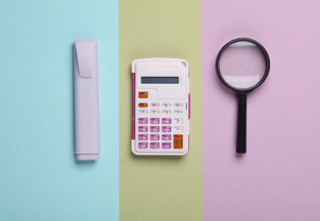 Marker, calculator and magnifier on a pastel background. School supplies