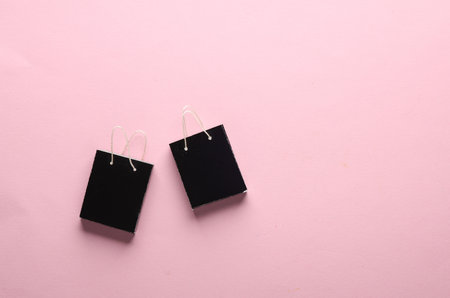Miniature black shopping bags on a pink background. Black Friday, world shopping day, saleの写真素材