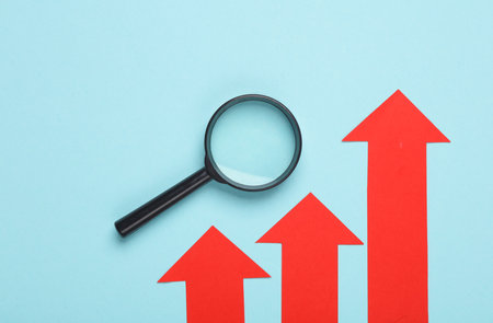 Magnifier with red growth arrows on a blue background. Business conceptの写真素材