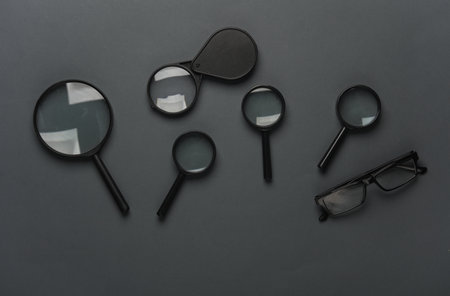 Magnifiers with eyeglasses on a dark gray backgroundの写真素材