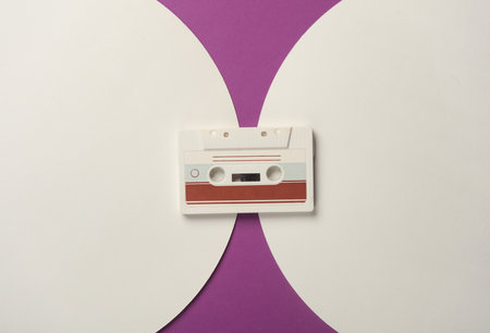 Retro 80s audio cassette on purple background with white circles. Top viewの写真素材