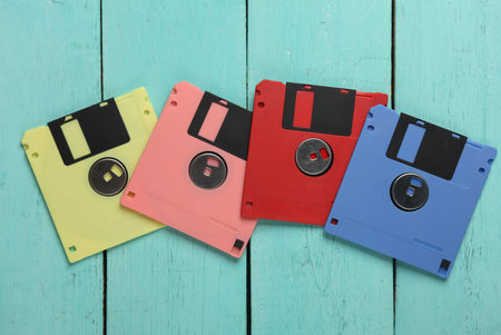 Set of colored floppy disks on blue wooden boards. Old fashioned technology, 80sの写真素材