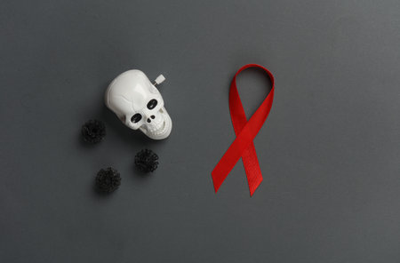 Red awareness ribbon with skull n on dark background. Worlds HIV Aids Day