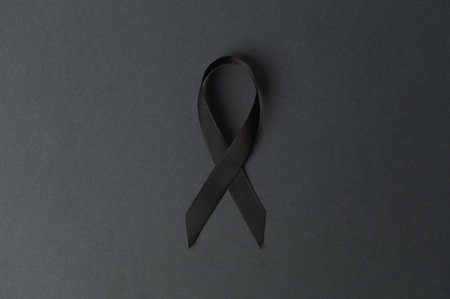 Black awareness mourning ribbon on dark background