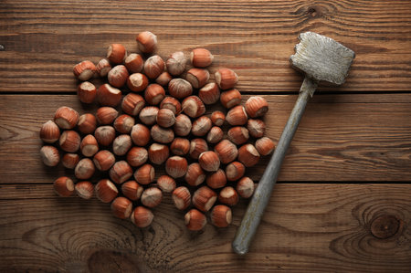 Hazelnuts and hammer on a wooden table. Top view.の写真素材