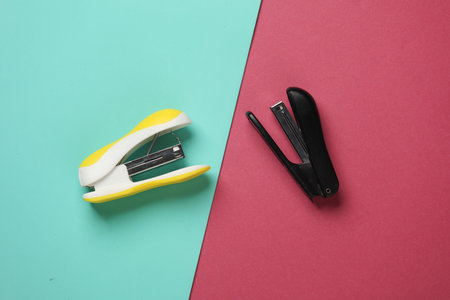 Two Staplers on pink blue background. Top viewの写真素材