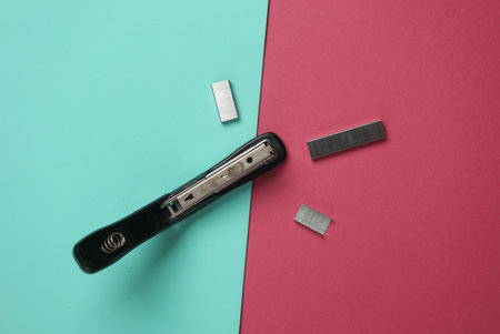Black Stapler with bullets starting on pink blue background