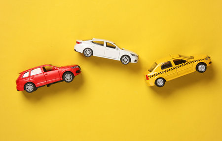 Car and taxi models on yellow background. Travel, vocation conceptの写真素材