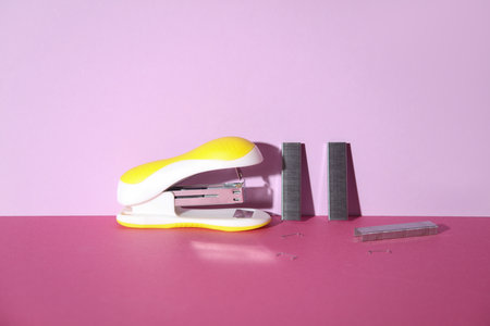 Yellow Stapler with bullets starting on pink background. Creative layoutの写真素材