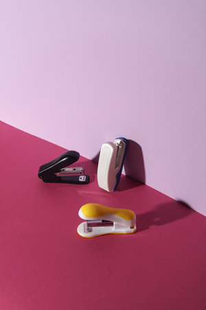 Staplers on pink background. Creative layout