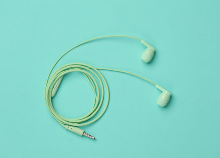 Wired earphones on a blue backgroundの写真素材