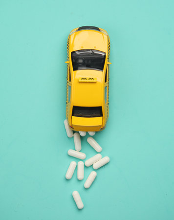 Taxi car with pills on a blue background. Top view