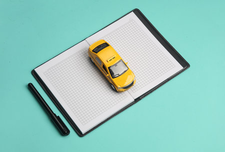 Taxi car with notebook on a blue background.の写真素材