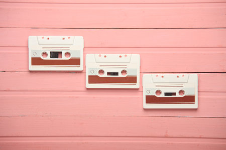Retro 80s audio cassettes on pink wooden boards. Top viewの写真素材