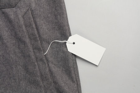 Jacket with white blank tag on a string. Shopping, sale concept. Template for design