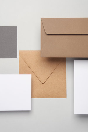 Floating envelopes and cards on gray background with shadow. Minimalism, modern business still life, creative layoutの写真素材