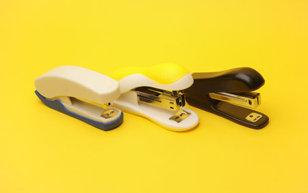 Staplers on a yellow background. Business conceptの写真素材