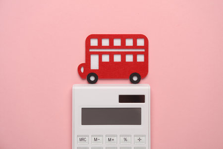 Toy bus made of felt and calculkator on blue background. Travel concept
