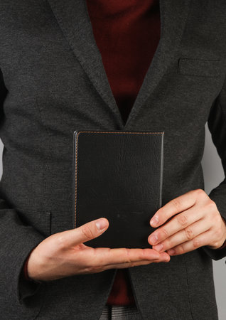 Business man holding black leather notebook